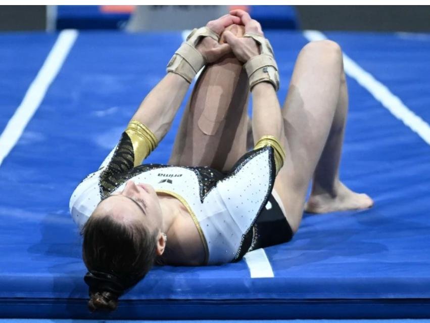 Helen Kevric holds her injured knee after a fall during the 2025 European Gymnastics Championships